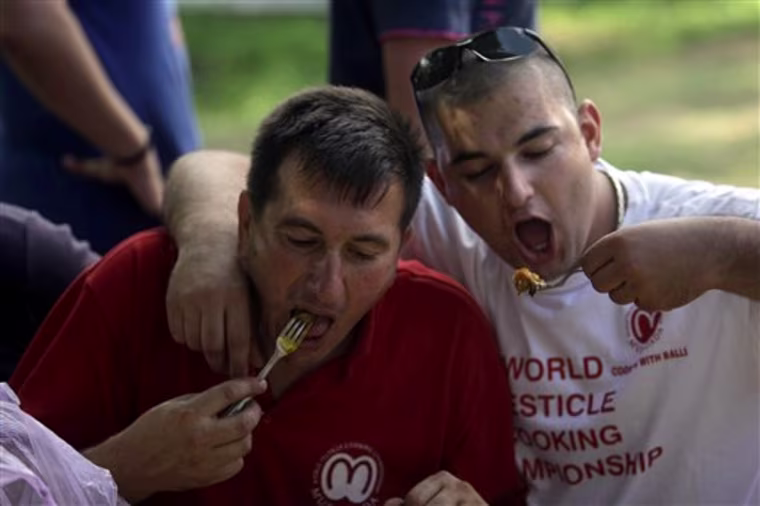 In this photo taken on Saturday, Aug. 28, 2010, the participants of the so-called 7th annual World Testicle Cooking Championship get a first taste of a dish that they prepared in the village of Ozrem, some 150 kilometers (90 miles) south of Belgrade, Serbia. At the seventh annual World Testicle Cooking Championship, visitors watch - and sometimes taste, as teams of chefs cook up bull, boar, camel, ostrich and even kangaroo testicles. (AP Photo/Marko Drobnjakovic)